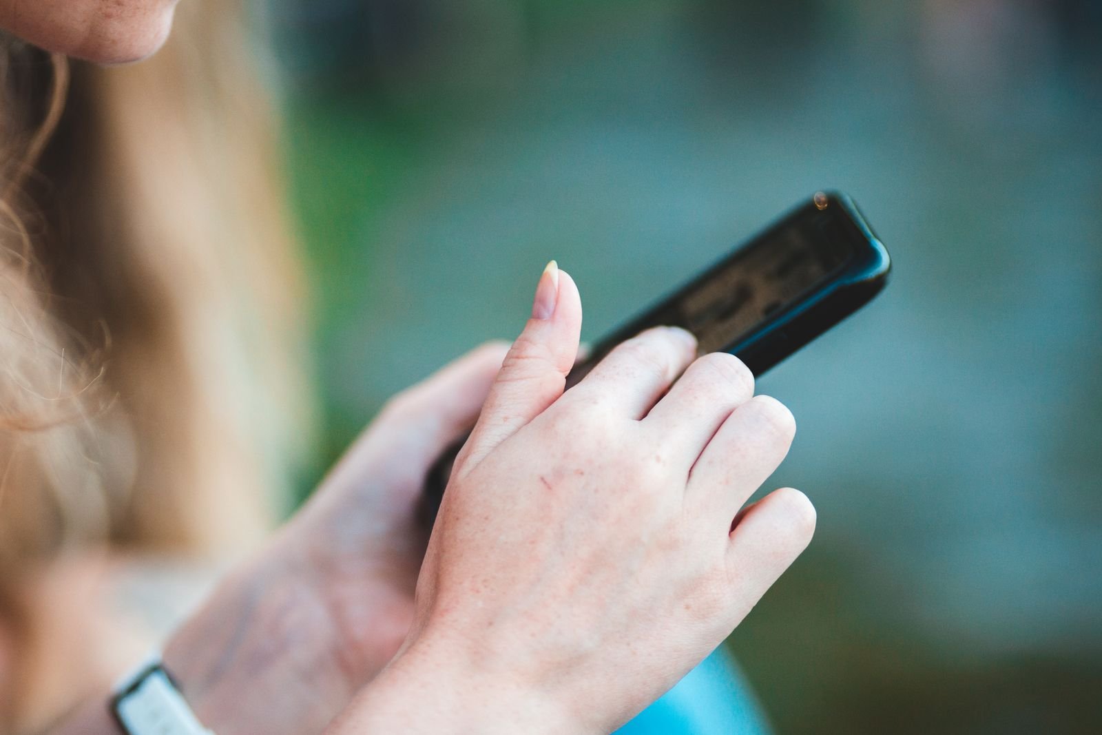 Hands holding an iPhone while adjusting Google app privacy settings