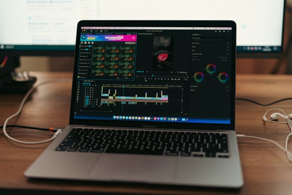 MacBook on a desk running video editing software with a timeline open