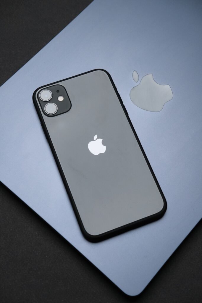 iPhone resting on a MacBook keyboard while checking for the latest iOS update