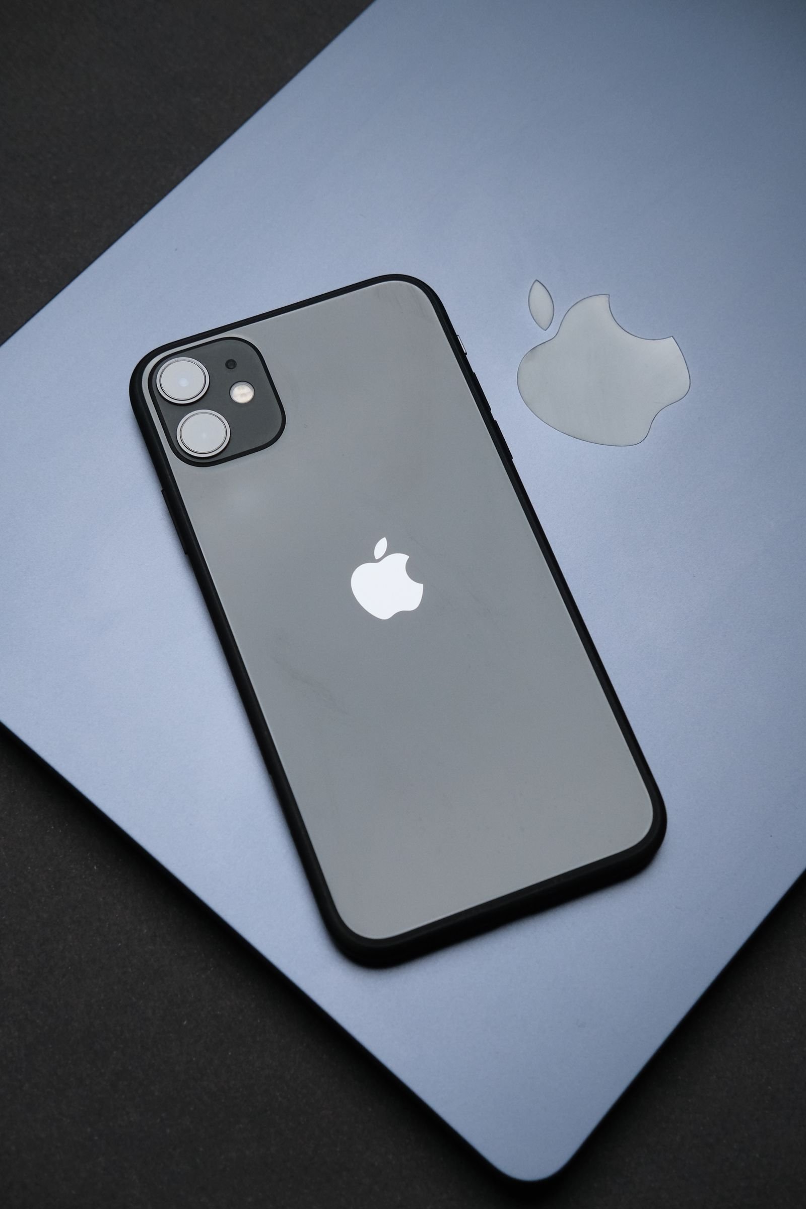 iPhone resting on a MacBook keyboard while checking for the latest iOS update