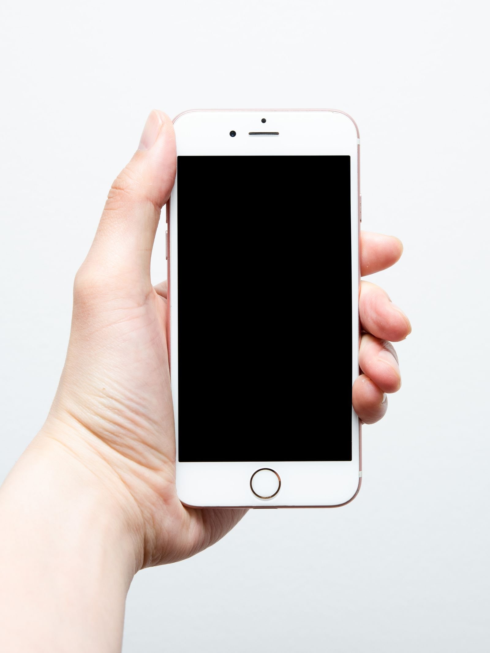 Hand holding an iPhone, checking security and privacy settings