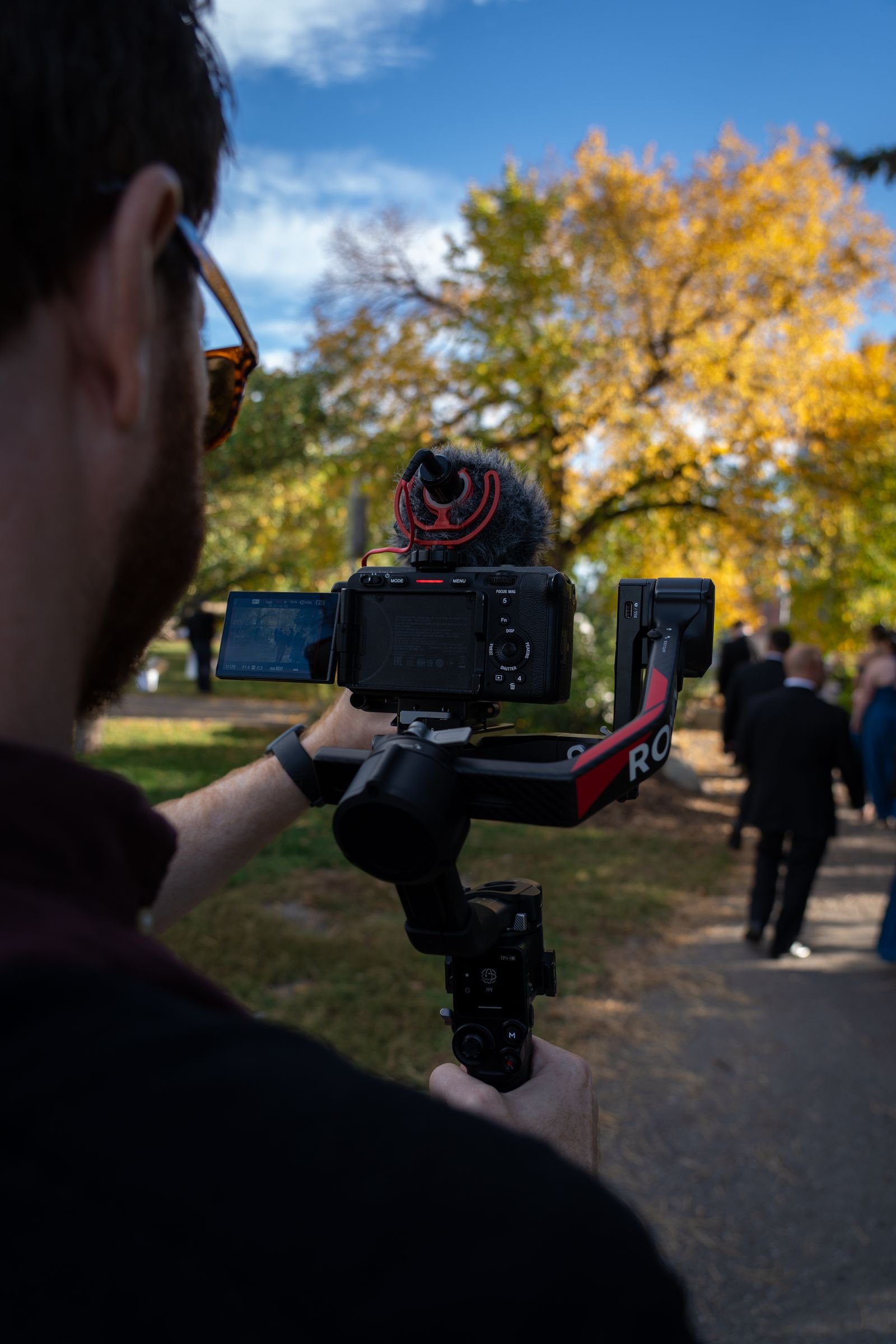 Videographer filming a wedding couple with a smartphone