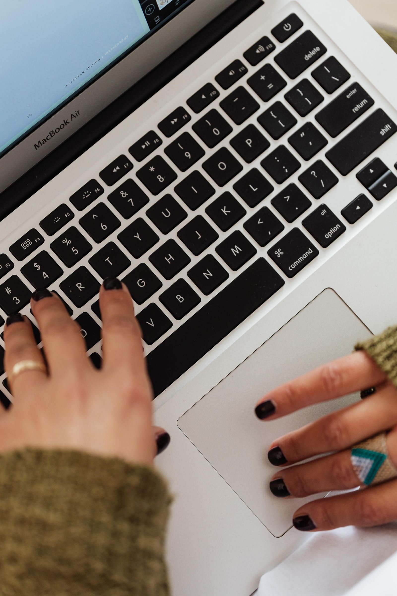 Hands typing on a MacBook Air used for video editing