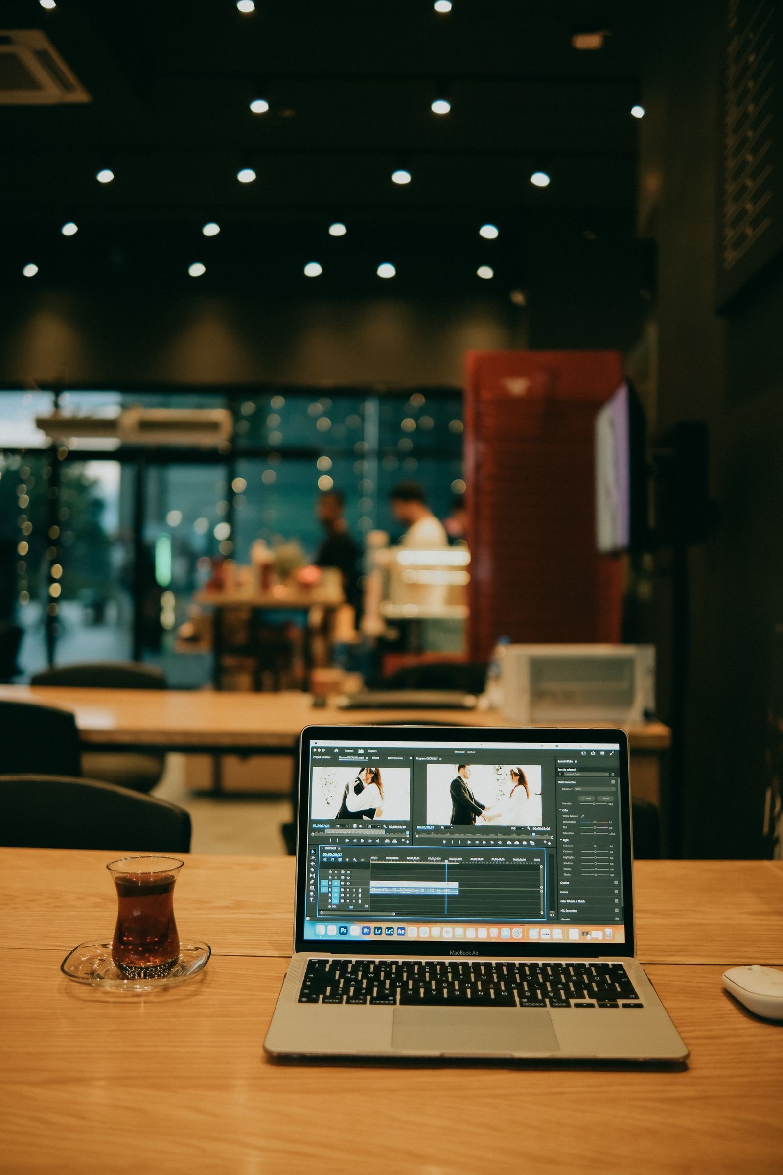 Laptop with a video editing timeline open in a cozy home desk setup