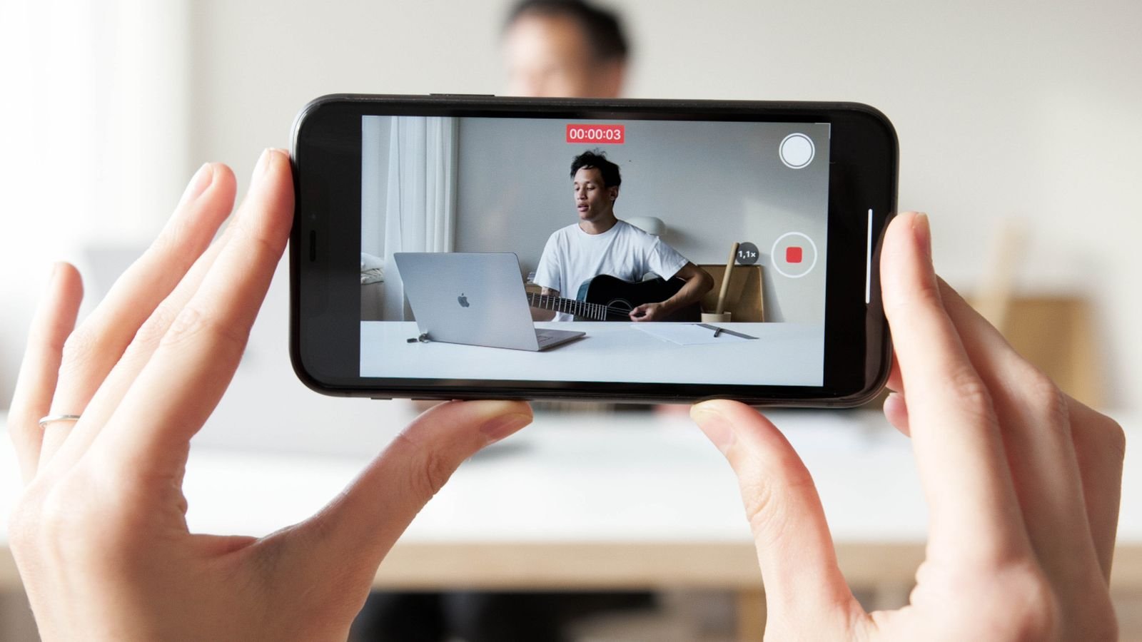 YouTuber recording a guitar vlog before editing it on a Mac
